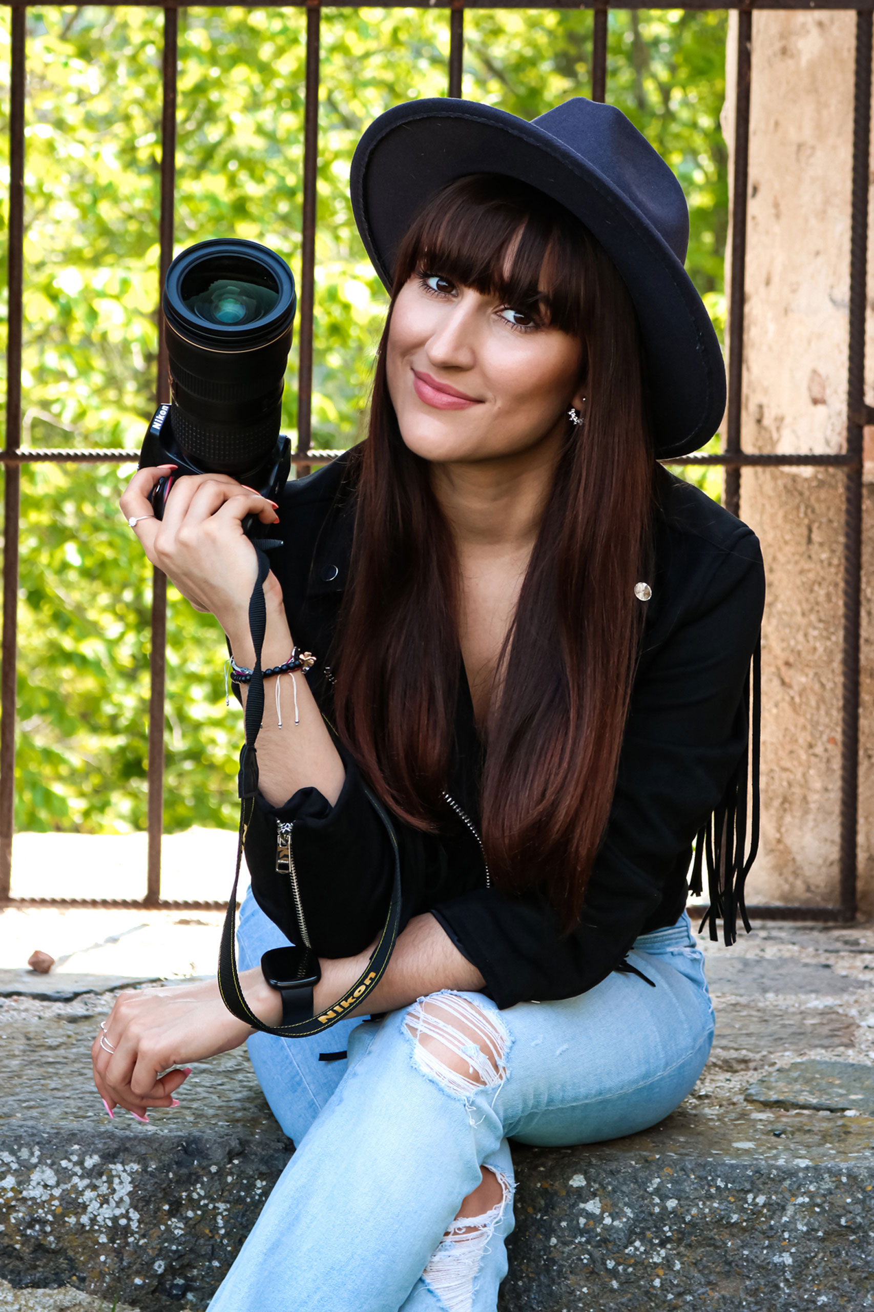 Jasmin sitzt in einer Ruine mit ihrer Kamera in der Hand